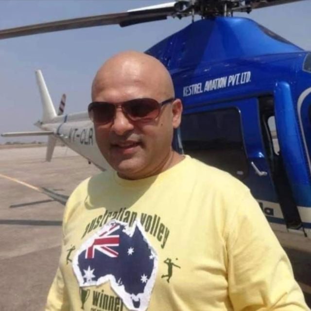 Deepak Bhanushali, founder of VENUES LOCATION, standing beside a helicopter on a film location shoot